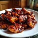 Close-up of Irresistible Honey Garlic Chicken Recipe pieces coated in a thick, glossy sauce and sprinkled with sesame seeds.