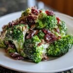 Close-up of Irresistible Honeycrisp Apple Broccoli Salad with creamy dressing, dried cranberries, and sunflower seeds.