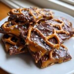 Close-up of broken pieces of Irresistible Salted Caramel Pretzel Bark topped with sea salt.