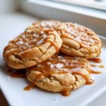 Close-up of Irresistible Salted Caramel Toffee Cookies drizzled with caramel and topped with sea salt flakes.