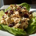 Shredded leftover turkey salad mixed with cranberries served in bright green lettuce cups.